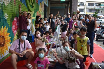 15組親子家庭挑戰親手包粽子-在彩繪牆旁合影留念