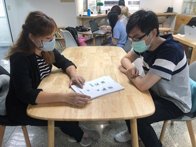 諮詢師與青年面對面諮詢,說明診斷測驗結果